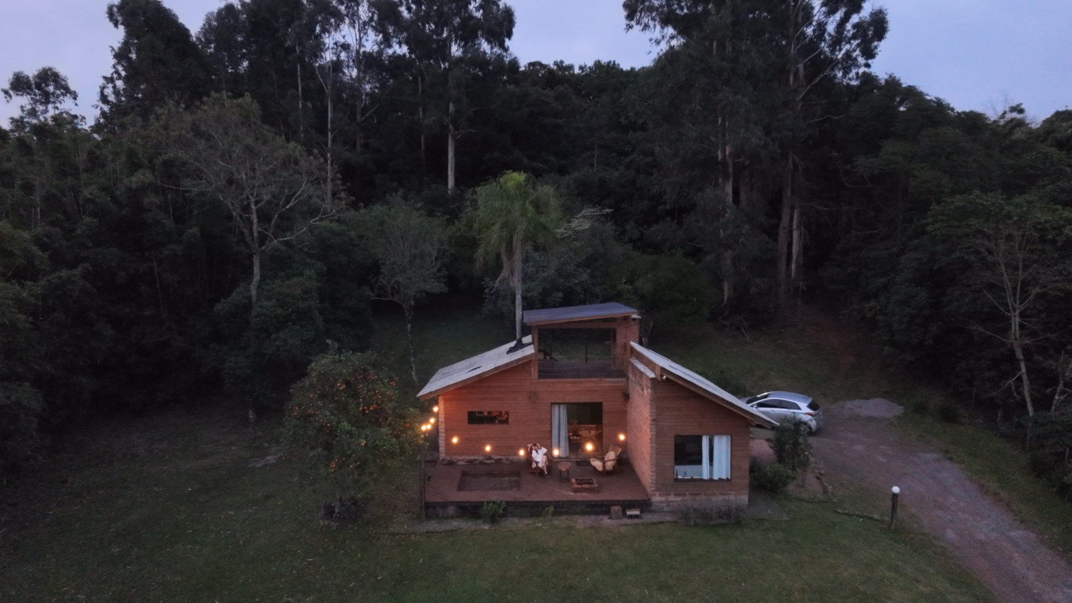 Casal relaxando em deck de cabana boutique cercada por natureza